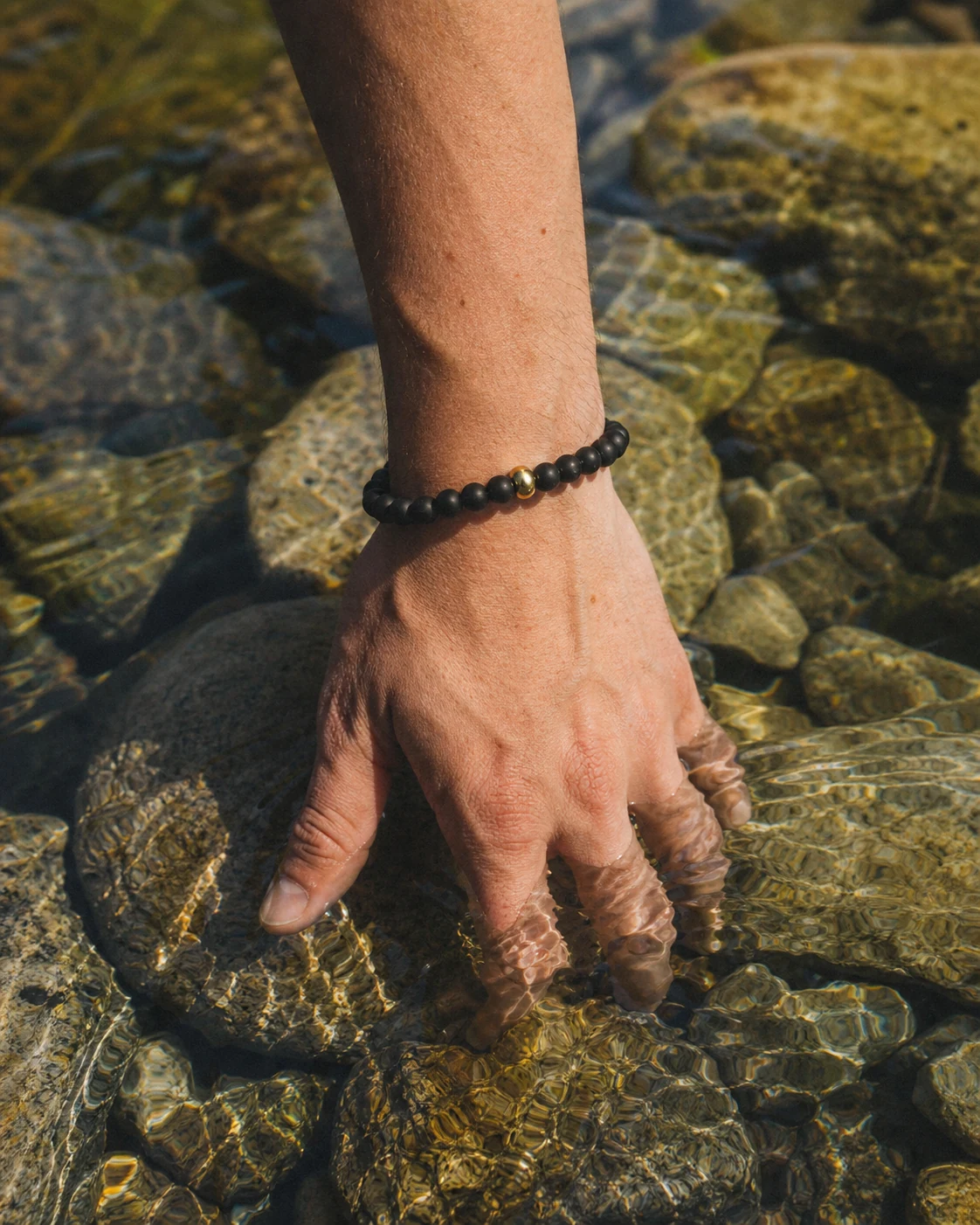 A dark stone bracelet worn in a quiet everyday scene